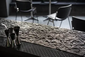 Industrial-style bar counter made of metal with a textured surface.