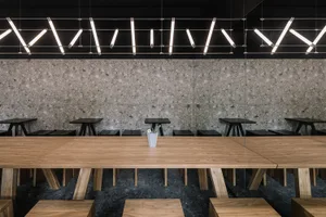 A minimalist cafe interior featuring wooden and concrete surfaces.