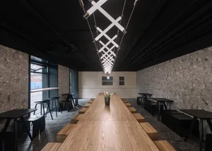 A minimalist coffee shop interior featuring wooden and concrete surfaces.