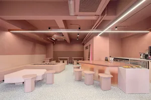 Modern cafe interior featuring pink concrete walls and flooring