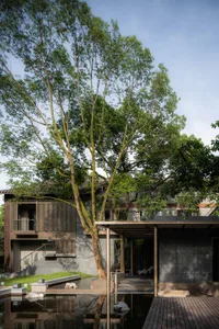 Modern minimalist house exterior featuring glass, wood, and stone materials.