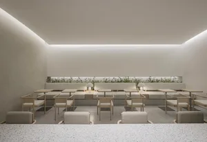 Modern minimalist restaurant interior with terrazzo flooring and seating.