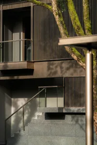Modern building exterior featuring large glass panels and metal railings.