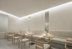 Minimalist cafe interior with modern furniture and terrazzo flooring.