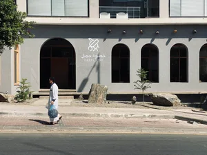 A modern-looking street-side coffee shop with a concrete structure and glass windows.