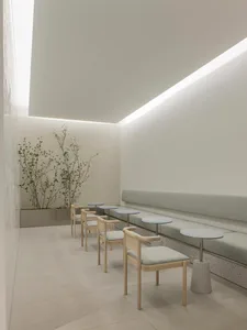 A minimalist coffee shop with concrete tables and seating area.