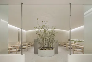 A minimalist modern cafeteria with terrazzo flooring and seating arrangements.