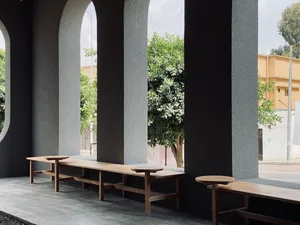 Outdoor seating area with wooden benches and concrete columns