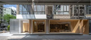 Modern retail storefront with glass windows and brick extension on a city street