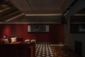 Modern living room with red leather furniture and geometric patterned floor.