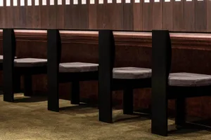 Modern black chairs with gray cushions in a sleek, minimalist seating arrangement.
