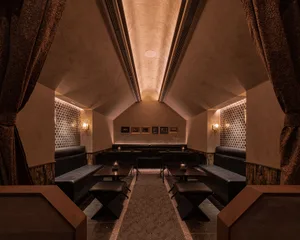 Industrial-style restaurant seating with leather booths and wooden tables.