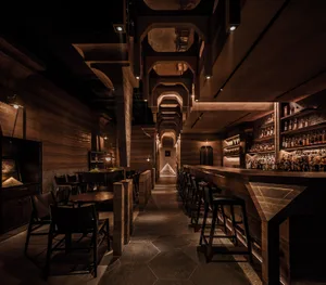 A modern bar with concrete and wooden elements.