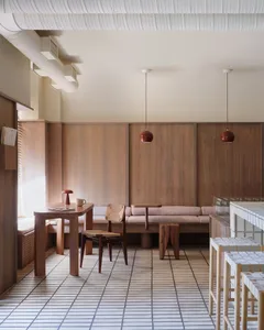 現代餐廳咖啡廳，配有木質家具、吊燈及軟墊座位區。