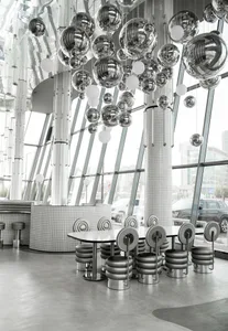 Restaurant interior with modern, metallic spherical decorations hanging from the ceiling.