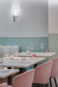 Modern restaurant interior featuring contemporary furniture and decor with terrazzo flooring and walls.