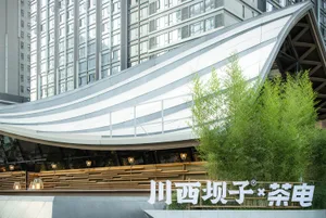 A modern retail storefront with glass walls and bamboo plants.