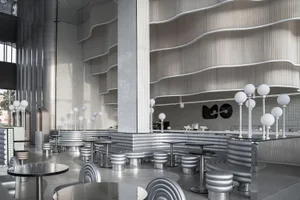 A contemporary metallic bar interior with sleek, curved furniture and a futuristic design aesthetic.
