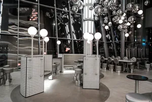 A modern restaurant interior with metallic elements and reflective surfaces.