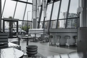 Modern restaurant interior with large glass walls and sleek, contemporary furniture.