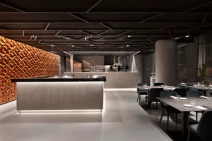 A minimalist restaurant interior with metallic and wooden elements.