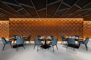 A modern restaurant interior with wooden walls, fabric chairs, and tables.