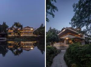 A serene residential exterior with illuminated windows and wooden structures surrounded by lush greenery.