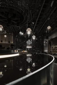Industrial design of a bar retail space featuring black metal elements and ambient lighting.