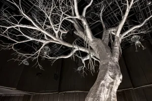 A textured, metallic tree sculpture with an industrial aesthetic.
