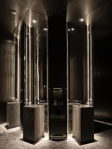 A modern, industrial-style washroom with metallic fixtures and a metallic floor.