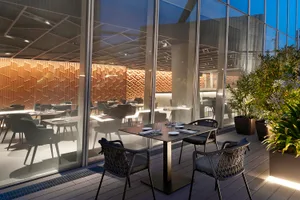 Modern luxury dining room with wooden paneling and glass furnishings, featuring sleek design and elegant atmosphere.