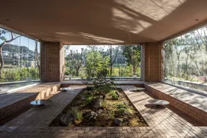 Modern lobby with minimalist design, brick walls, and glass windows.