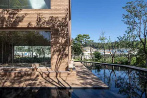 Modern brick house with large glass walls and a glass pool.