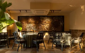 A beautifully designed cafe interior featuring wood, stone, and fabric elements.