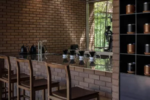Modern coffee shop interior with brick walls and concrete countertops.