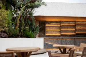 A modern restaurant exterior featuring copper replacement shingles and terrazzo.