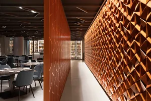 Modern restaurant interior with wooden bar and tables.