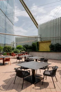 Outdoor seating area with modern furniture and metal tables at a rooftop restaurant