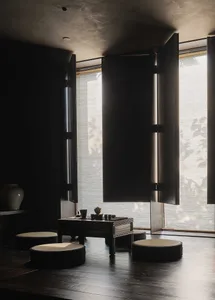A minimalist tea room with wooden furniture and fabric cushions.