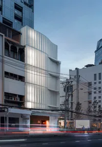 An image of a modern building facade with a metallic cladding surface.