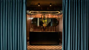 Modern restaurant bar with dark interior design and elegant decor, featuring metal accents, glass countertops, and wood furni