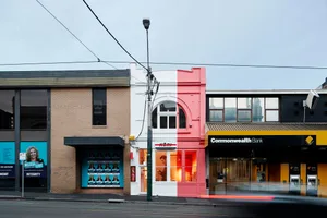 A row of urban storefronts, featuring brick and painted exteriors.