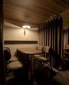 A cozy, private dining room with upholstered chairs and fabric curtains.