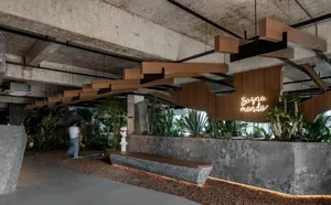 Concrete and wooden indoor courtyard with greenery and wooden benches.