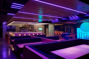 A modern restaurant featuring LED lighting and wooden benches