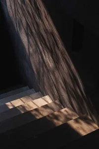 Modern concrete staircase with glass ombre lighting, showcasing contemporary design elements.