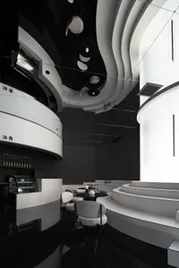 A modern restaurant interior with concrete walls, glass counter, and seating area.