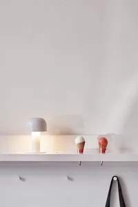 Minimalist white plastic shelf with a white table lamp and ice cream cones.