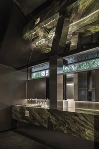 A modern bathroom featuring marble materials and dark lighting.