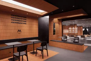 A modern cafeteria space with wooden walls and seating areas.